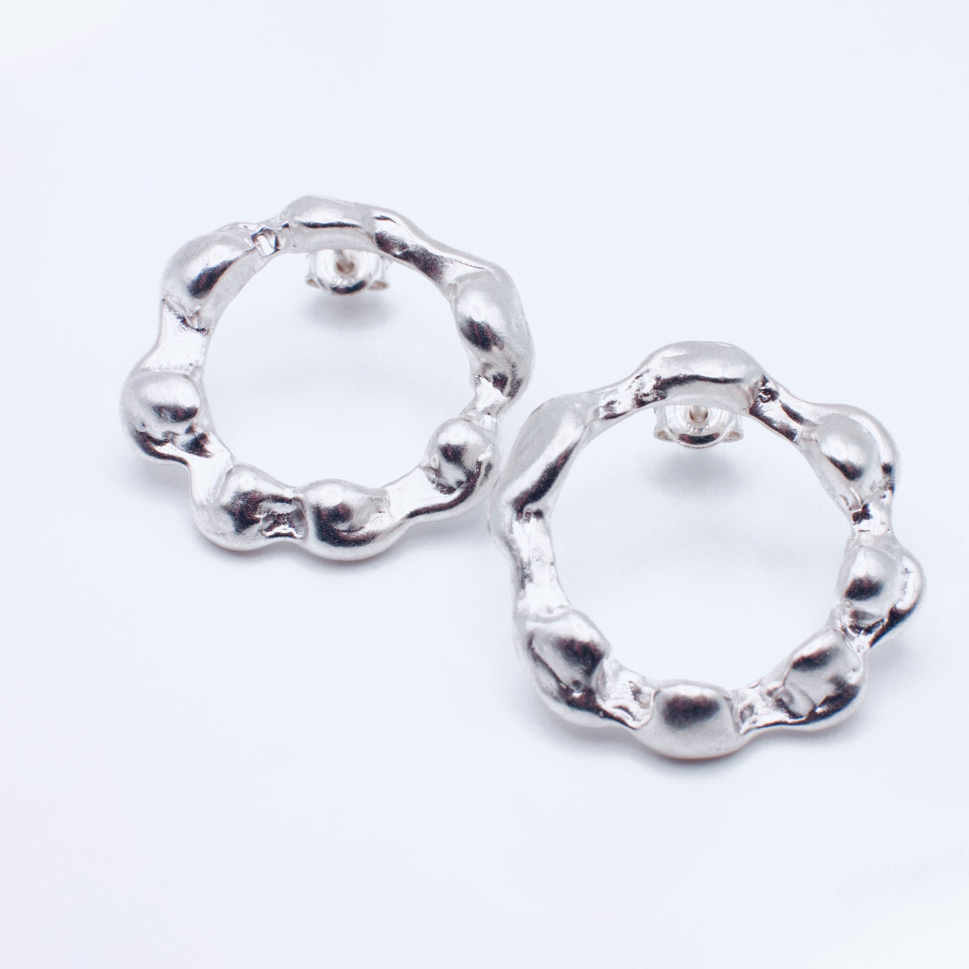 Pair of silver hoop earrings on a white background