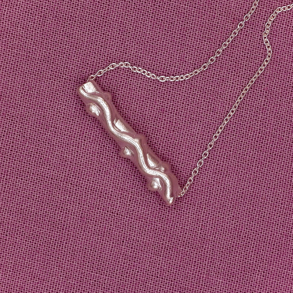 bracelet with a unique pendant on a pink textured background