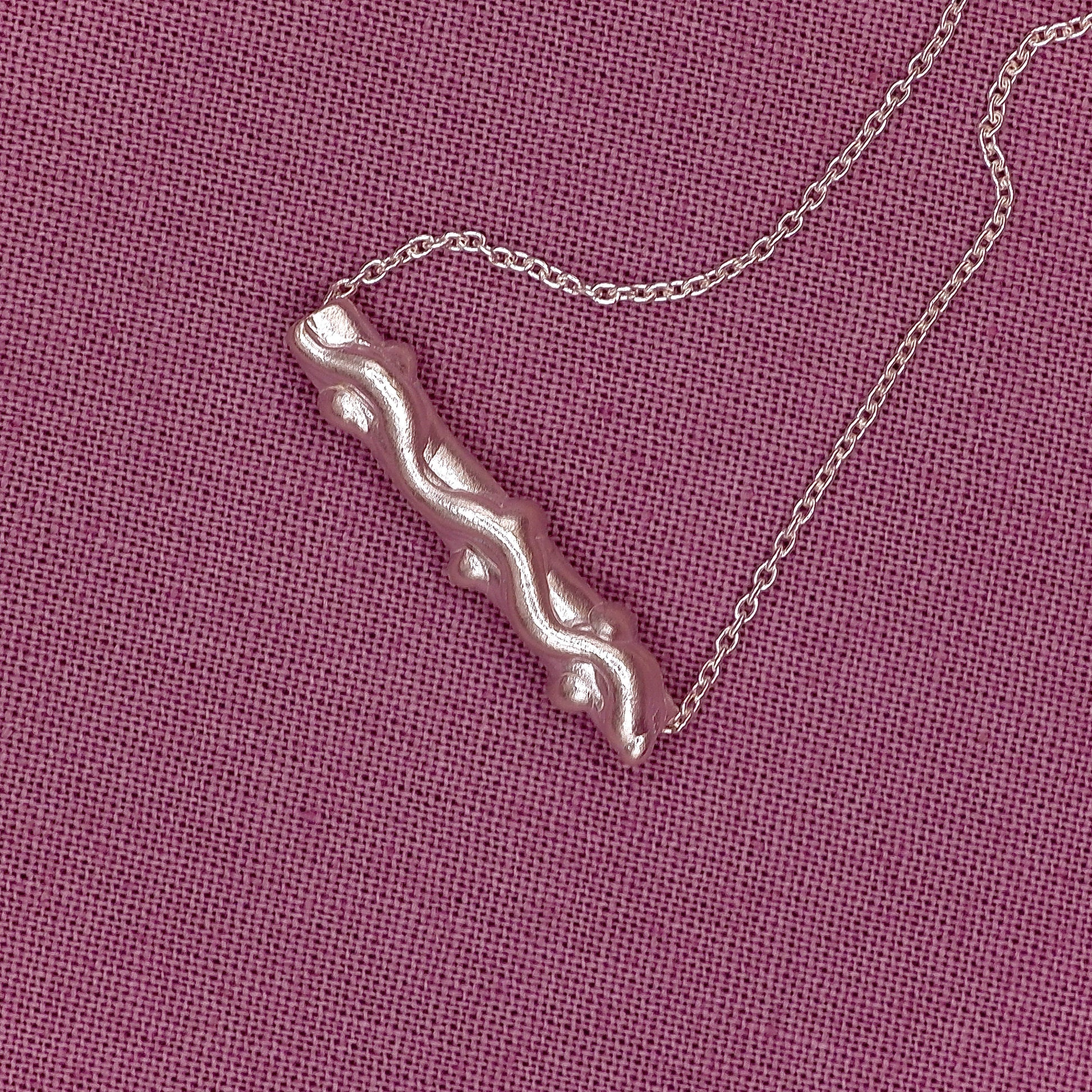 bracelet with a unique pendant on a pink textured background