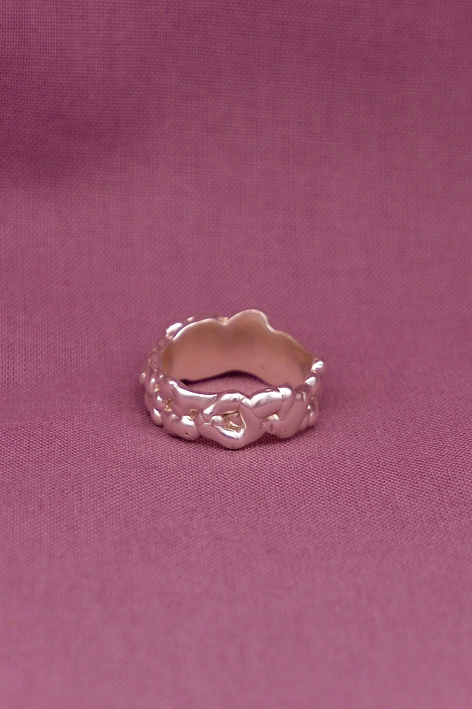 Silver ring  on a pink fabric background