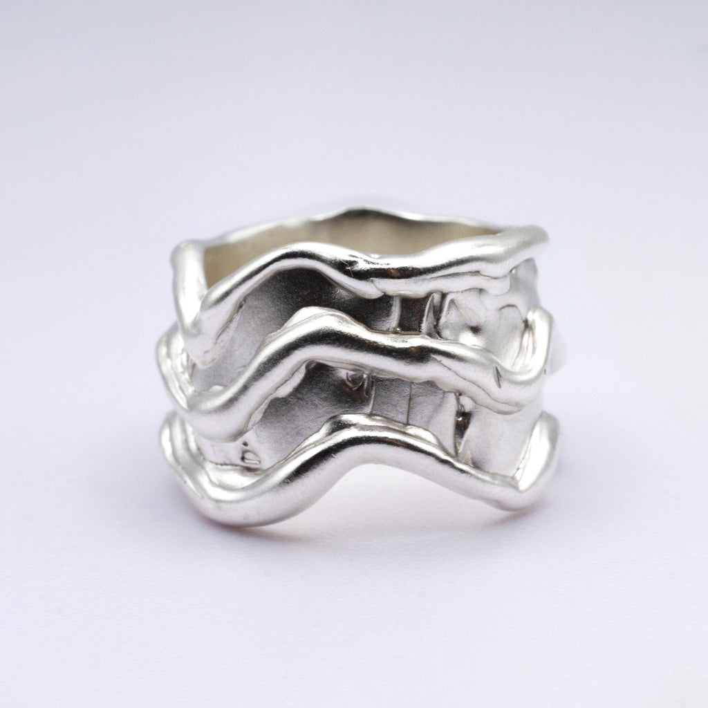 Silver wavy ring on a light gray background