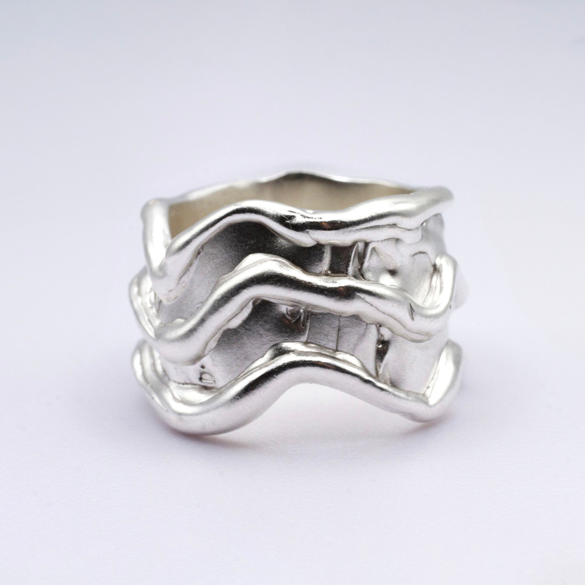 Silver wavy ring on a light gray background