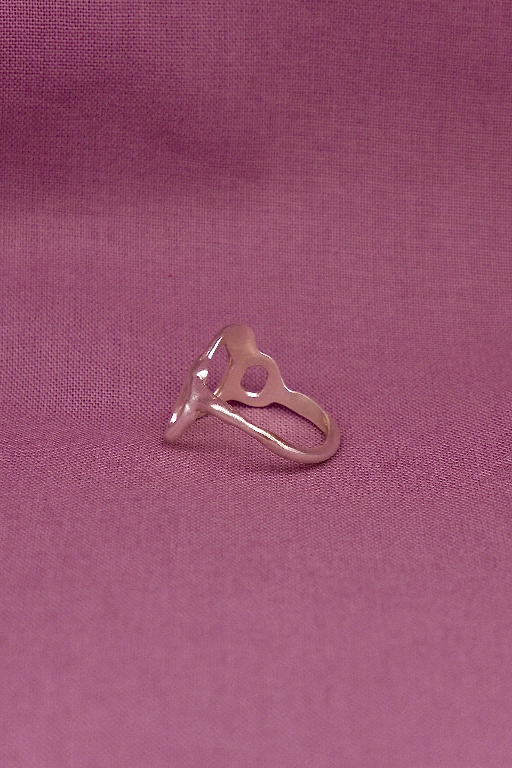 Silver ring on a purple fabric background