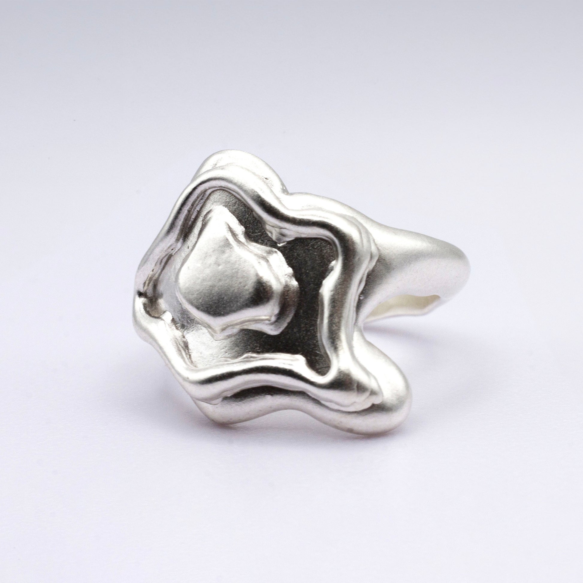 Silver ring with a unique design on a white background