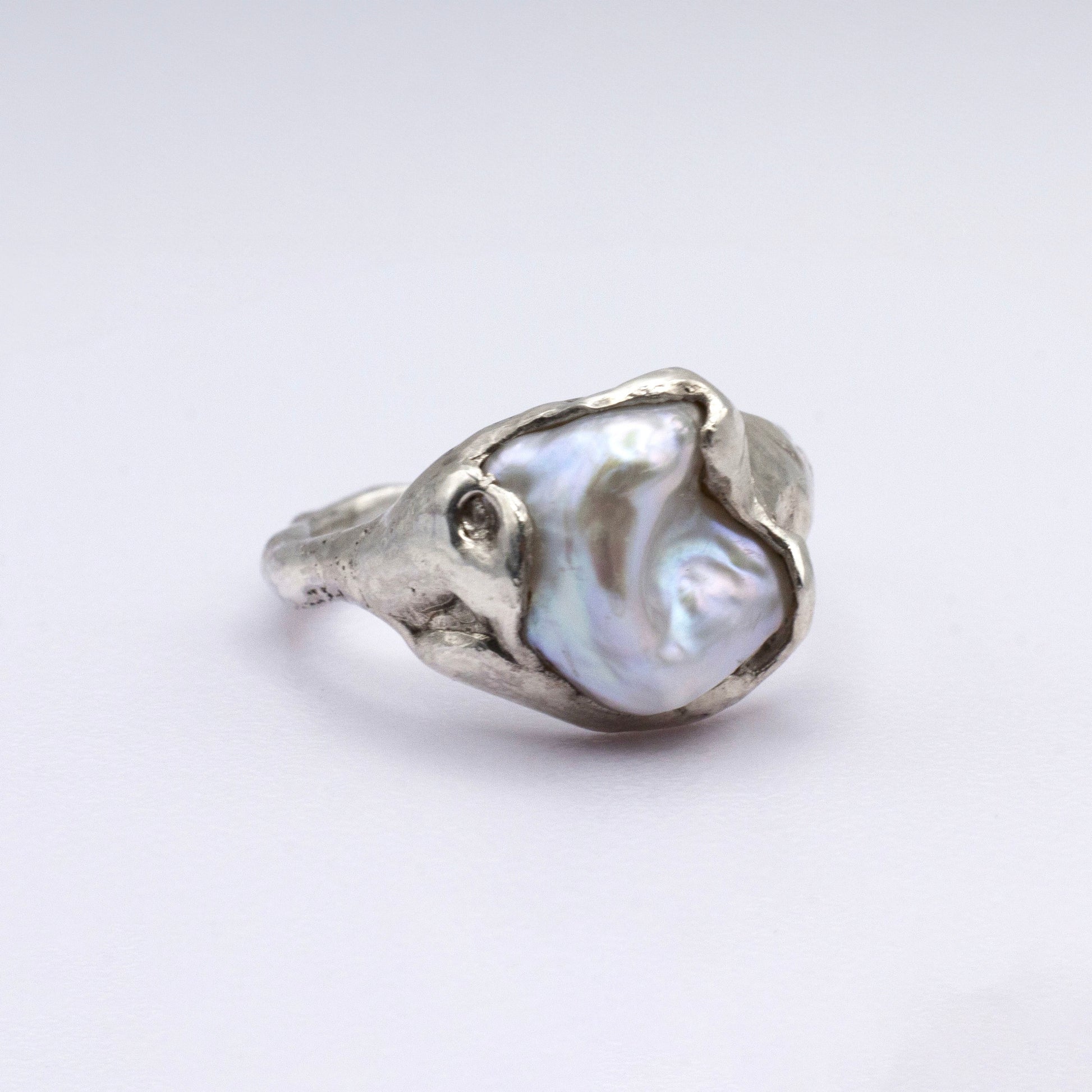 Silver ring with a large pearl on a white background