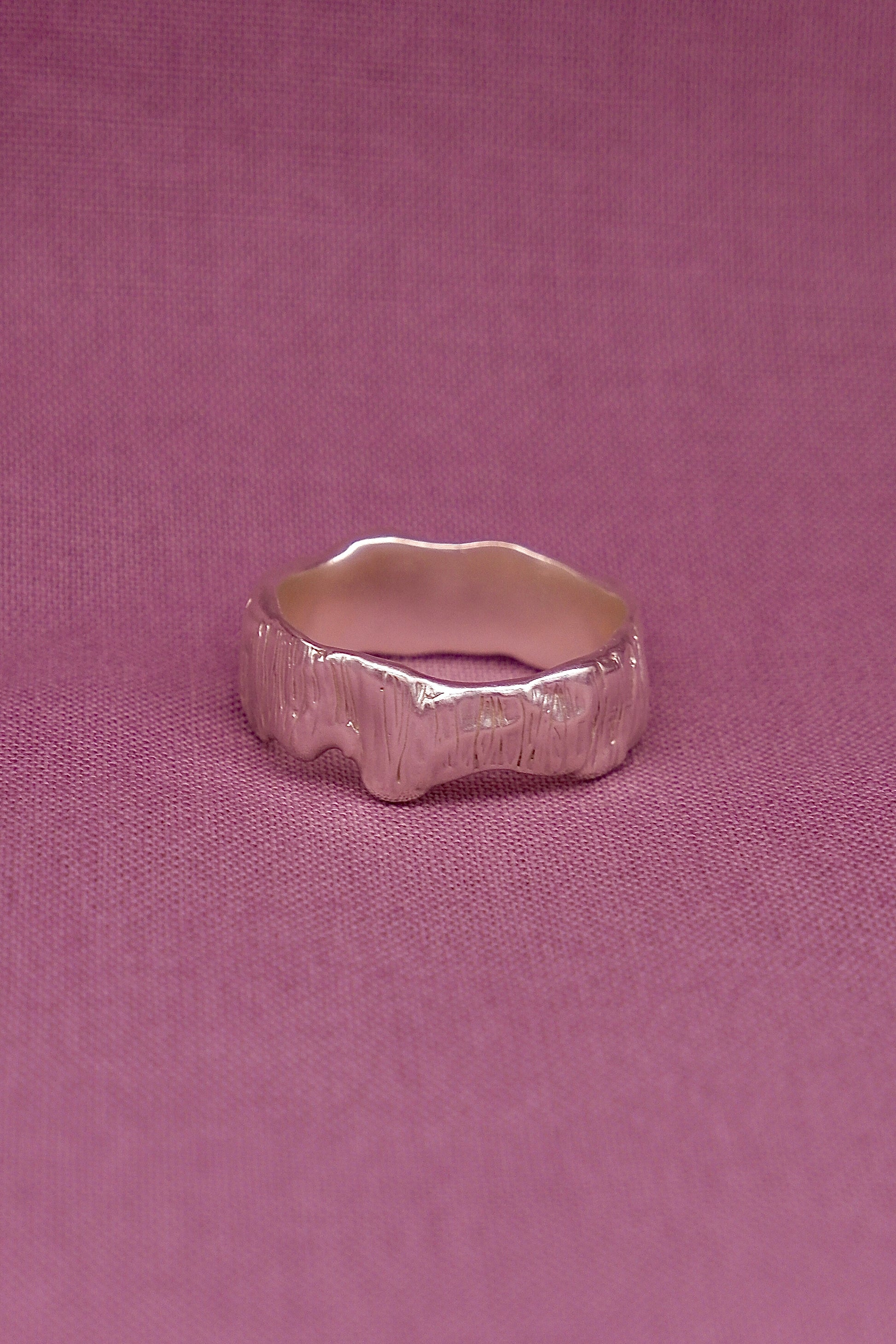 Silver ring on a pink fabric background