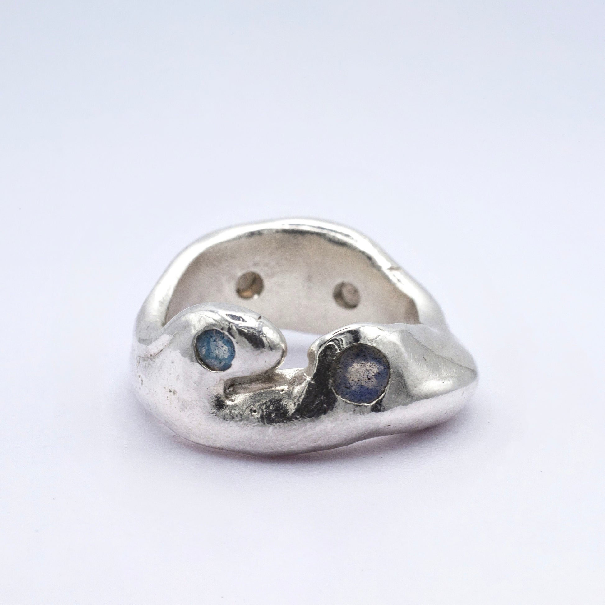 Silver ring with embedded stones on a white background