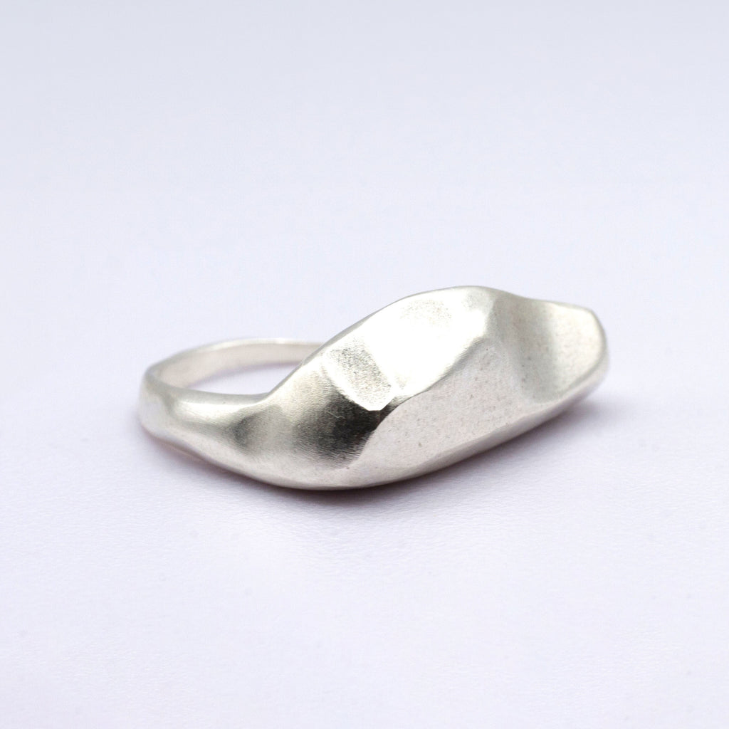 Silver ring on a light purple background