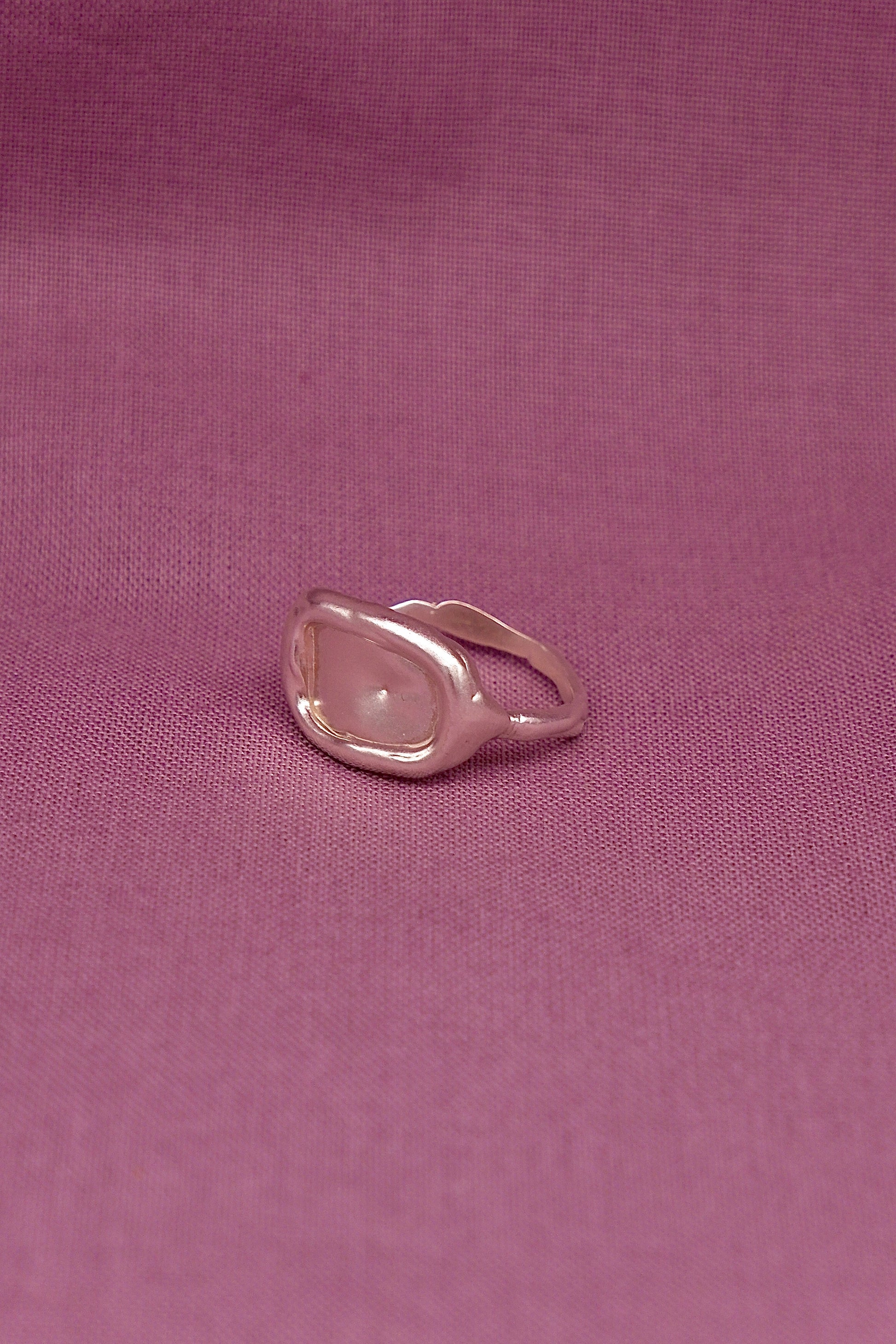 Silver ring  on a purple fabric background