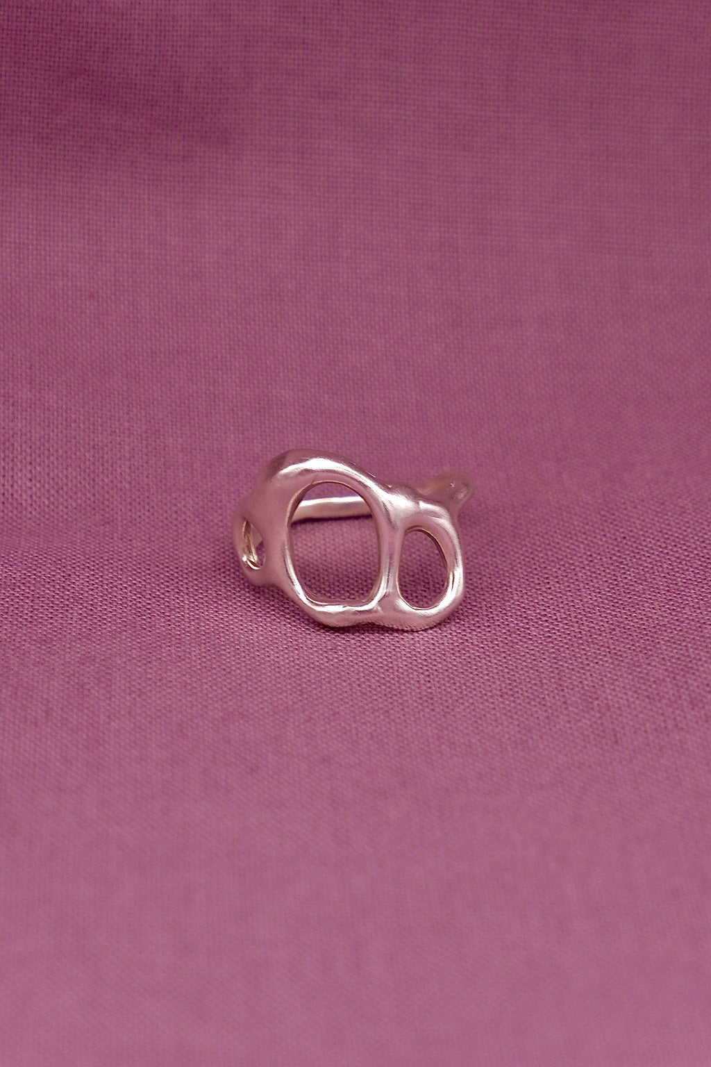 Silver ring on a purple fabric background