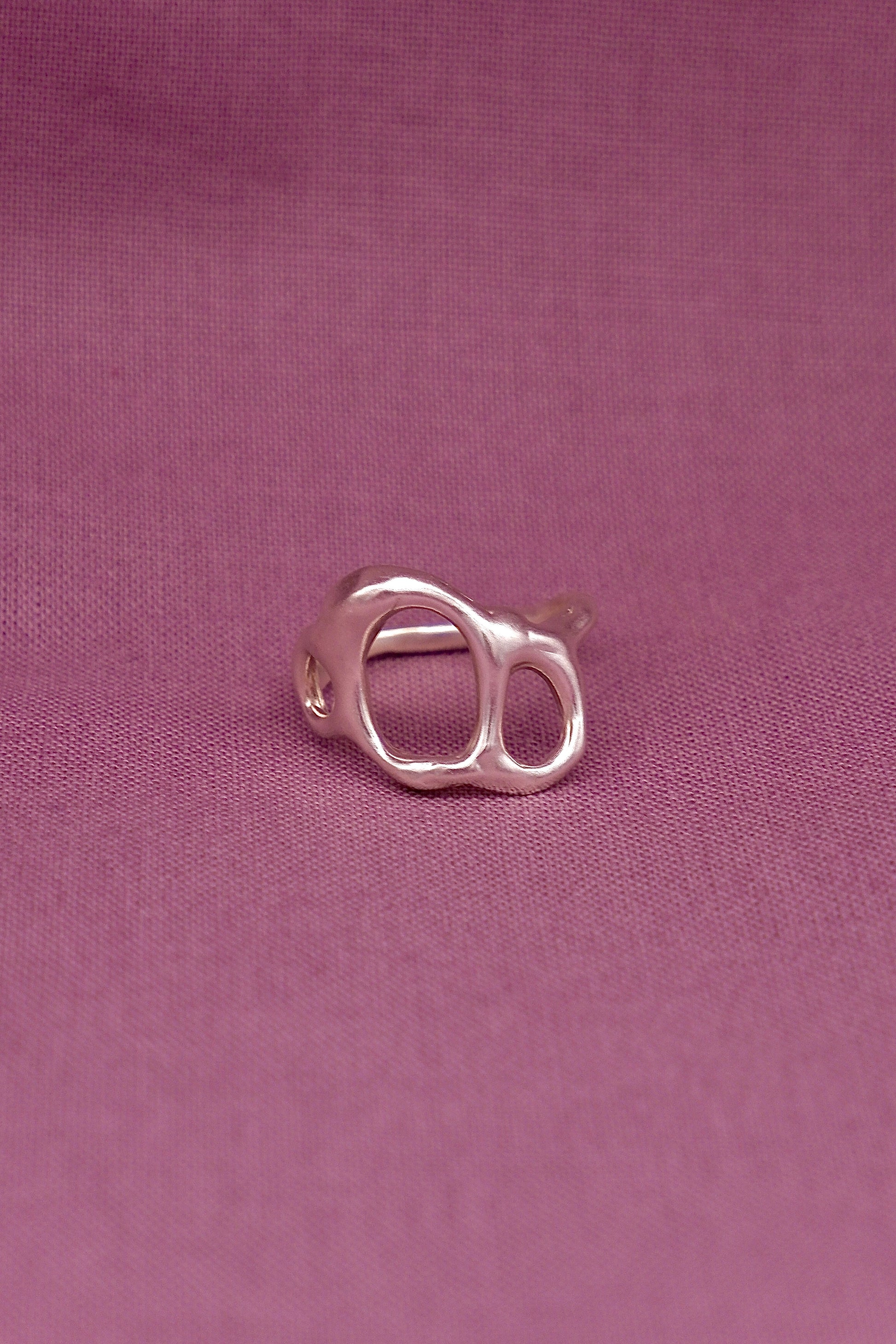Silver ring on a purple fabric background