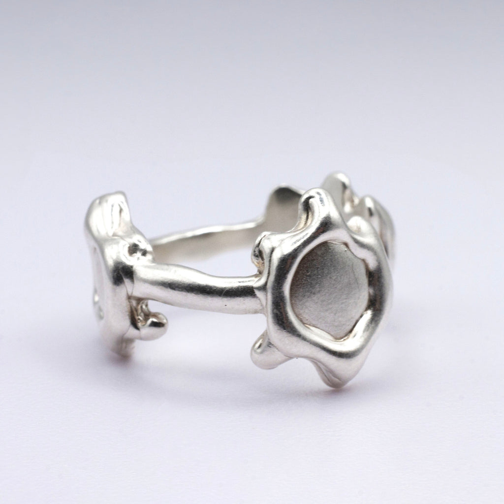 Silver ring with a unique design on a light gray background