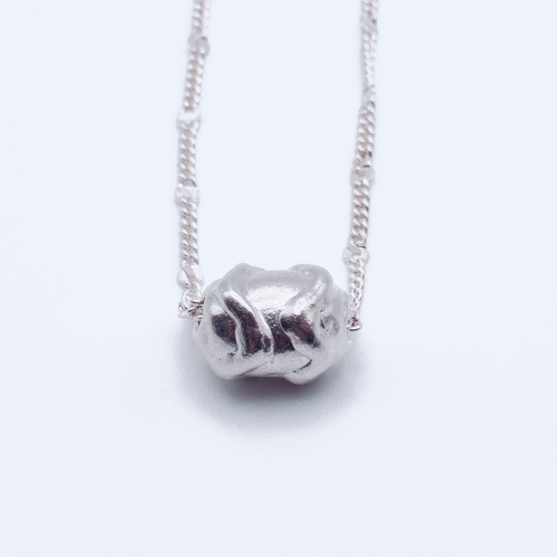 Silver  pendant on a chain against a white background