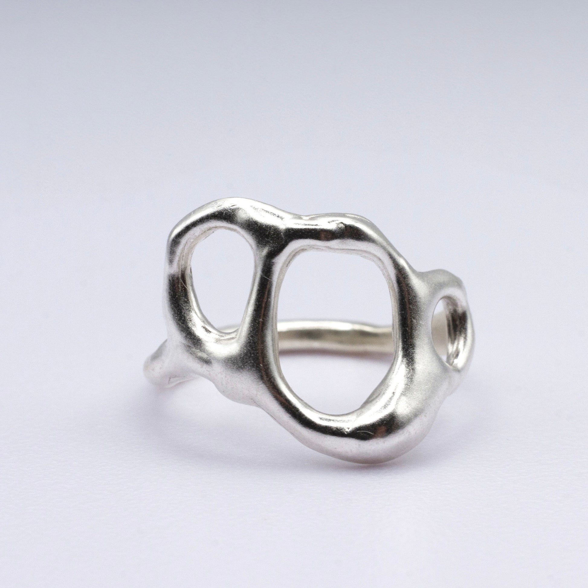Silver ring with a unique design on a light gray background
