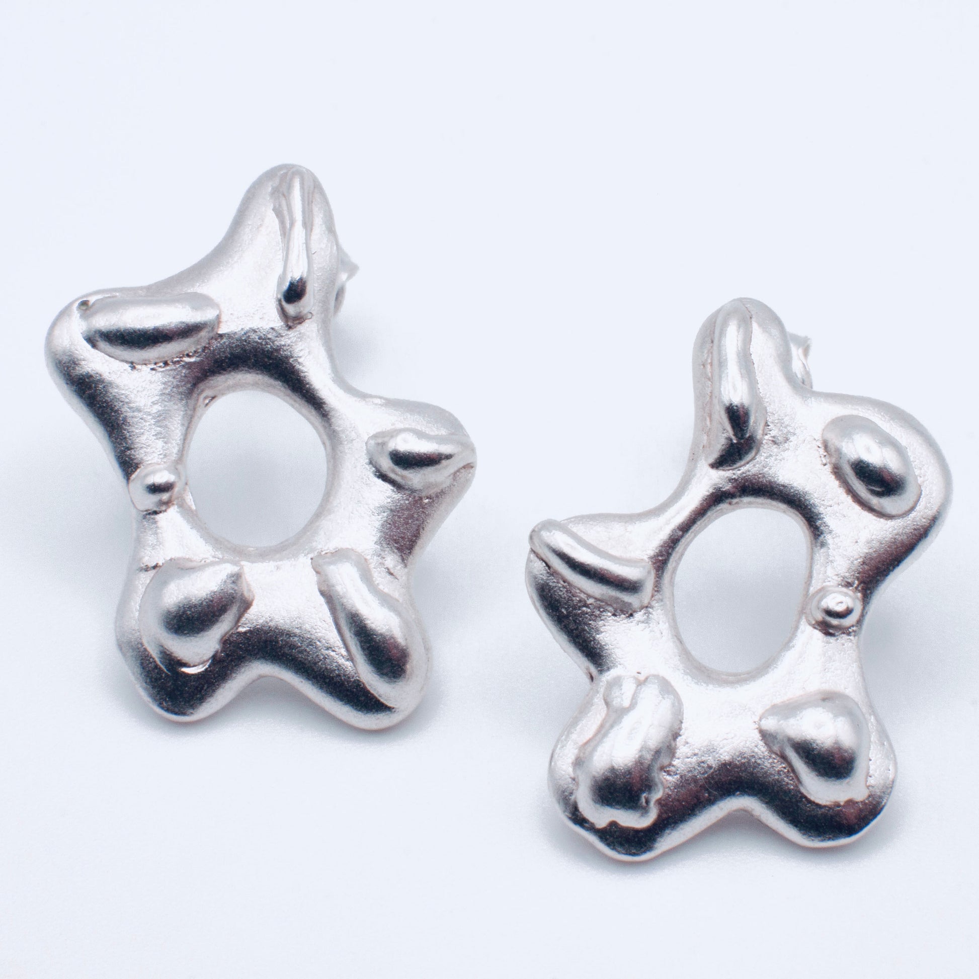 Silver star-shaped earrings on a white background