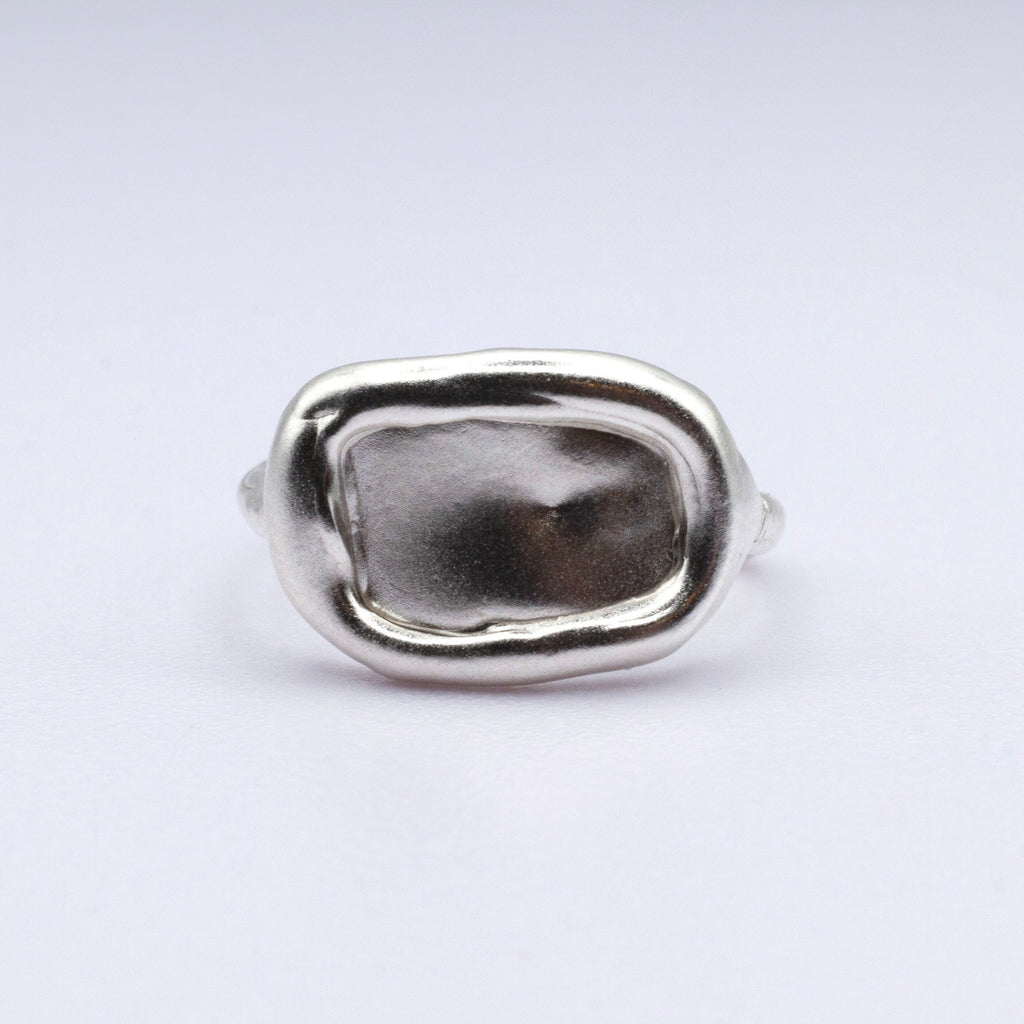 Silver ring with  on a light gray background
