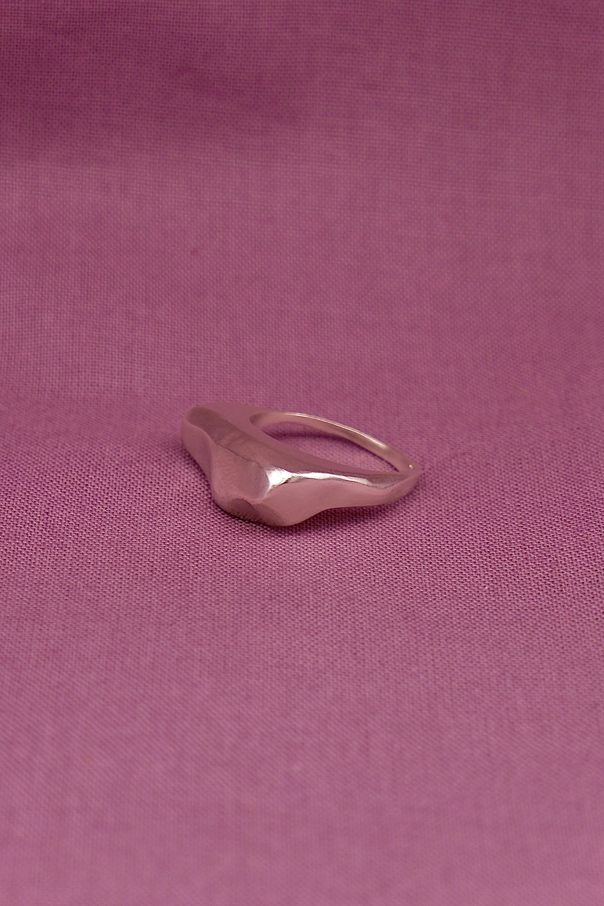Silver ring on a pink fabric background