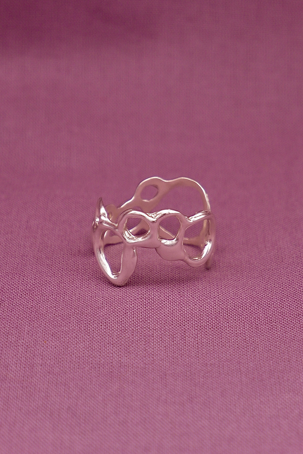 Silver ring on a pink fabric background